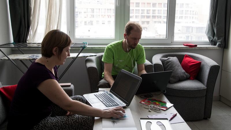 Russian immigrants Sergey Naumeno (36) and his wife, Natalya Vinagradova (38), work from their new temporary apartment in Yerevan. Photograph: Daro Sulakauri/The New York Times