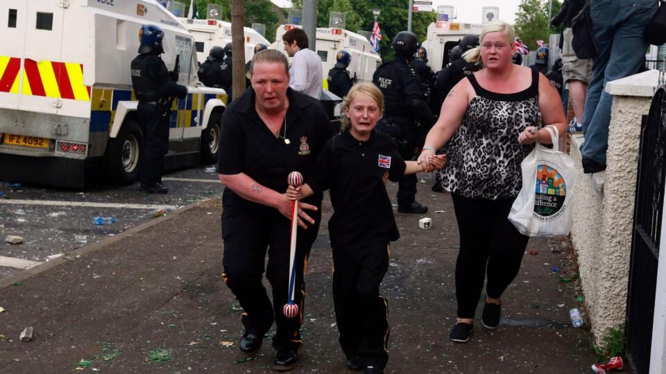 A young girl is rushed to safety as loyalists clashed with police in the Woodvale Road area of north Belfast last Friday. Photograph: Cathal McNaughton/Reuters