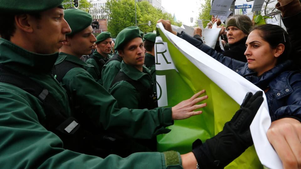 Police block protesters outside the courthouse. Photograph: Kai Pfaffenbach/Reuters