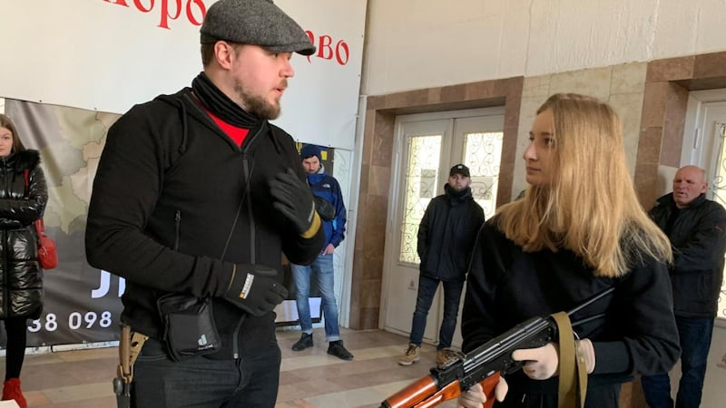Finnish weapons instructor Tomi Hiltunen with one of the civilians he is teaching to fire a Kalashnikov. Photograph: Lara Marlowe