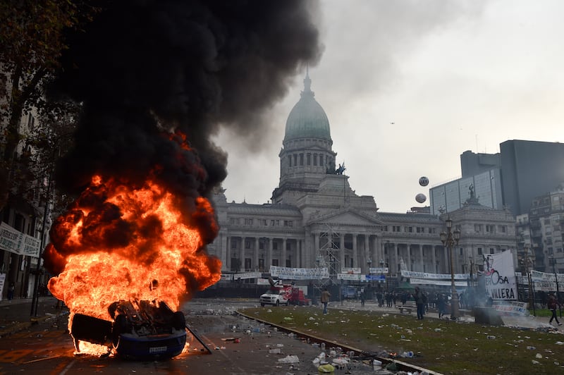 A car burns during clashes between police and anti-government protesters in Buenos. Photograph: Gustavo Garello/AP