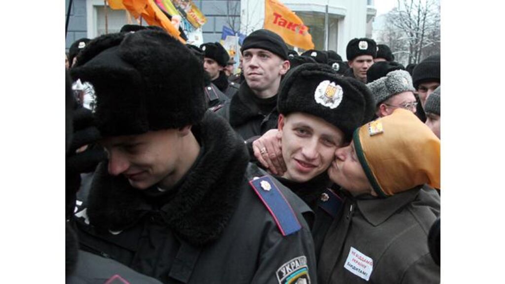 A supporter of Mr Viktor Yushchenko kisses an interior ministry soldier near the presidential office in Kiev yesterday. Photograph: Mikhailo Markiv