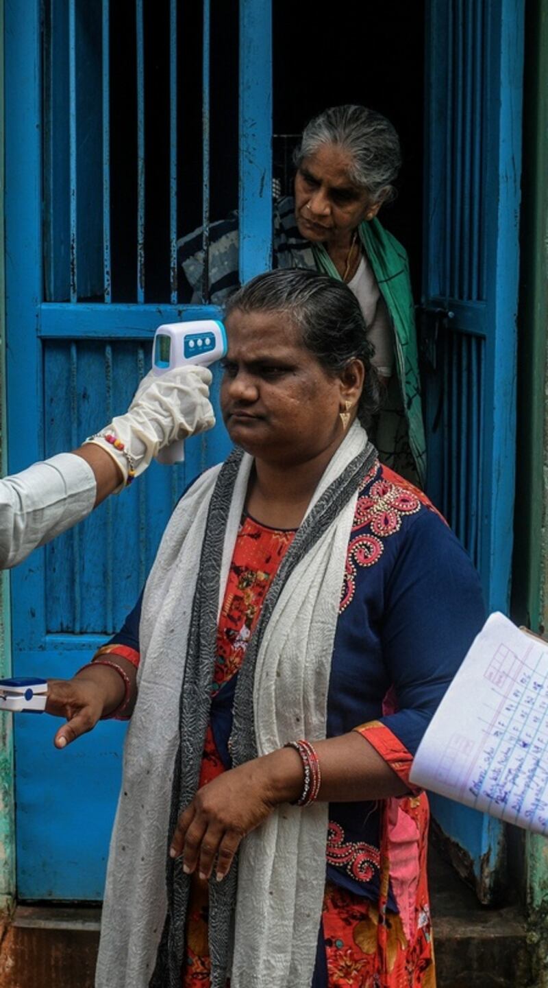A health care worker takes a person’s temperature in November, in Ganjam, a rural district of India that was untouched by the coronavirus until migrant workers began to return home. Photograph: Atul Loke/The New York Times