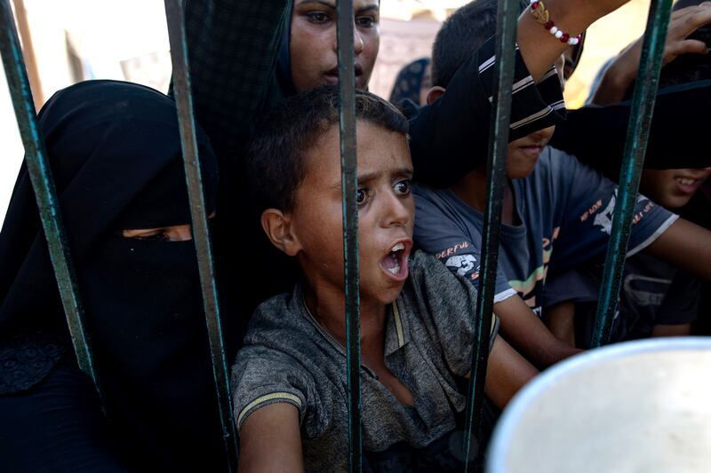 Palestinian women and children wait to collect food donated by a charity in Khan Younis camp, southern Gaza Strip. Photograph: Haitham Imad/EPA