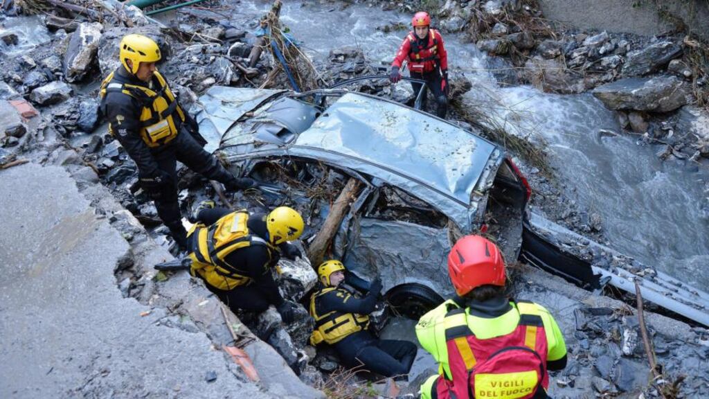Police and fire brigade members take part in search operations for a missing person after torrential rain in Serra Ricco near Genoa in Italy today. A wave of storms and torrential rain killed four people overnight near the Italian-Swiss border. Photograph: Luca Zennaro/EPA.