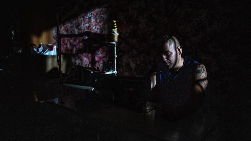 Mustafa Nabo, a tailor who fled the Syrian civil war, sits in a darkened apartment in Beirut. Photograph: Bryan Denton/New York Times
