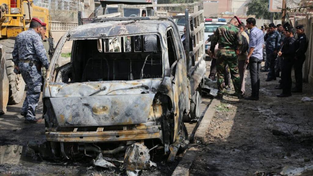 Iraqi policemen inspect the site of a car bomb attack at Karada district in Baghdad, Iraq, one or a number of roadside bombs set off in recent days