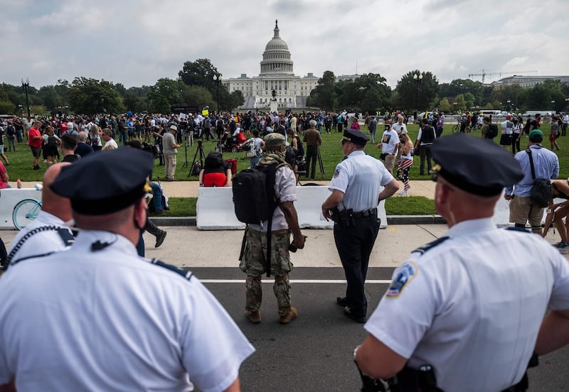 Police officers watch demonstrators taking part in the ‘Justice for J6’ rally in Washington DC on Saturday. Photograph: Andrew Caballero-Reynolds/AFP via Getty