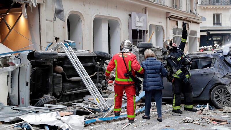 A woman is evacuated by firefighters after the explosion of a bakery on the corner of the streets Saint-Cecile and Rue de Trevise in central Paris. Photograph: Thomas Samson/AFP/Getty Images
