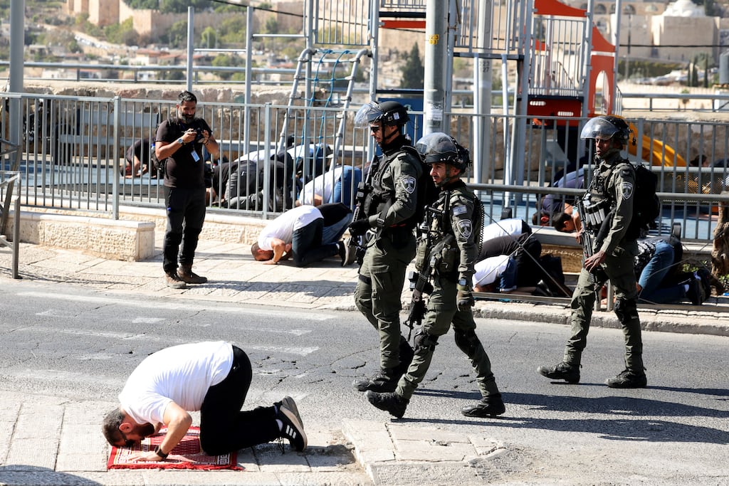 Israeli security forces walks past a Muslim Palestinian man as he takes part in Friday Noon prayers in East Jerusalem's neighborhood of Ras al-Amud. Photograph: Ahmad Gharabli/AFP via Getty