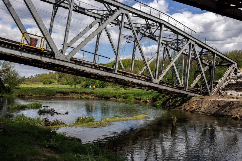 Two men walking along the Irpin River approach a destroyed railway bridge in Irpin, a suburb of Kyiv on Monday. Photograph: Ivor Prickett/The New York Times