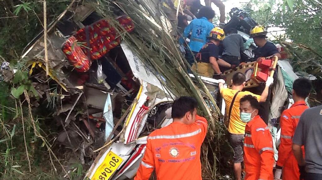 Thai rescue workers remove bodies and injured Malaysian passengers from the wreckage of a tourist bus after it crashed on a mountain roadside in the Doi Saket district in northern Thailand. Photograph: EPA