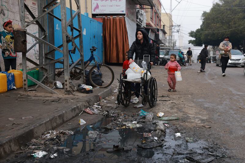 A child transports empty bottles on a wheelchair, on his way to fetch water in Rafah. Photograph: Mohammed Abed/AFP/Getty Images