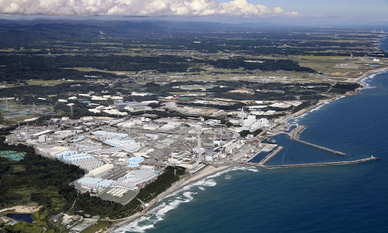 This aerial view shows the tanks, seen foreground, which contain treated radioactive wastewater at the Fukushima Daiichi nuclear power plant in Fukushima, northern Japan (Kyodo News via AP)