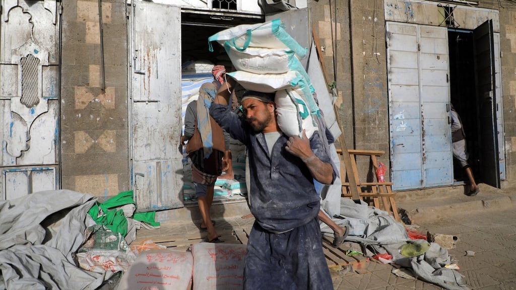 A Yemeni worker carries a bag of flour outside a wholesale shop in Sana’a: With the country almost completely dependent on imports, aid groups say the situation will worsen following Russia’s invasion of Ukraine. Photograph: Mohammed Huwais