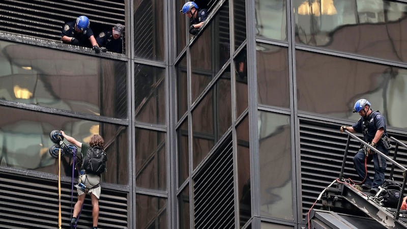 Police waiting to grab a man who scaled the all-glass facade of the 58-storey Trump Tower in New York on Wednesday. Photograph: Julie Jacobson/AP