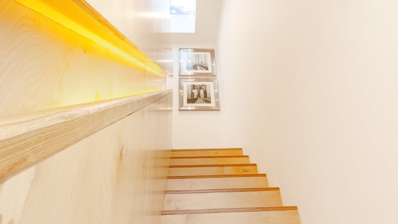 The staircase linking the two levels is a striking feature, custom-made in beech ply, with concealed storage and nice detailing in the backlit integrated handrail.