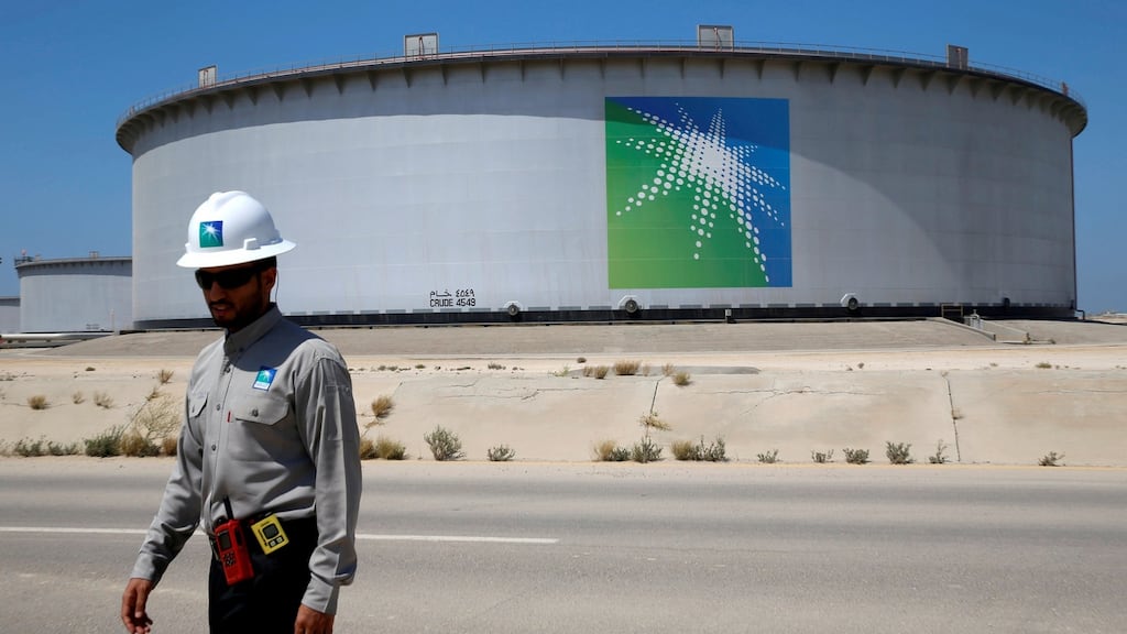 An Aramco employee walks near an oil tank at Saudi Aramco’s Ras Tanura oil refinery and oil terminal in Saudi Arabia.