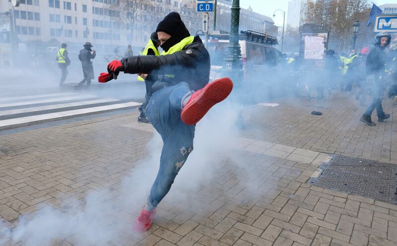 A protester kicks back a tear gas catridge as during the protest in Brussels, Belgium on November 30th Photograph: Olivier Hoslet/EPA