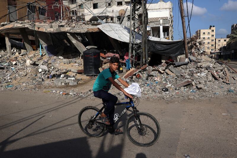 A Palestinian boy rides a bicycle past a destroyed building in Rafah on Sunday. Photograph: Eyad Baba/AFP via Getty