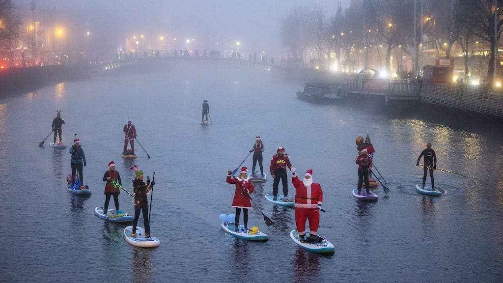 A group of paddle boarders imbued with the Christmas festive spirit on the River Liffey in Dublin. Photograph: Tom Honan