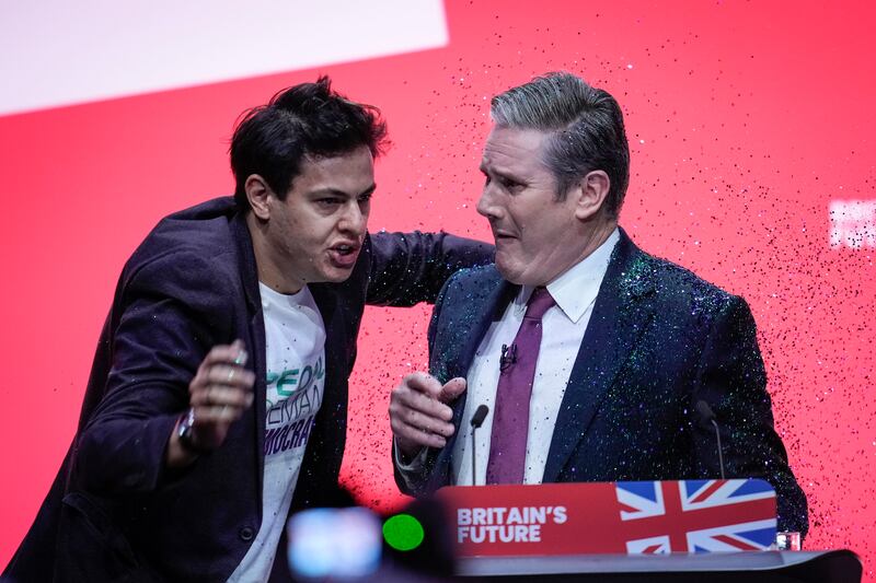 A protester storms the stage and throws glitter over Labour party leader Keir Starmer. Photograph: Christopher Furlong/Getty