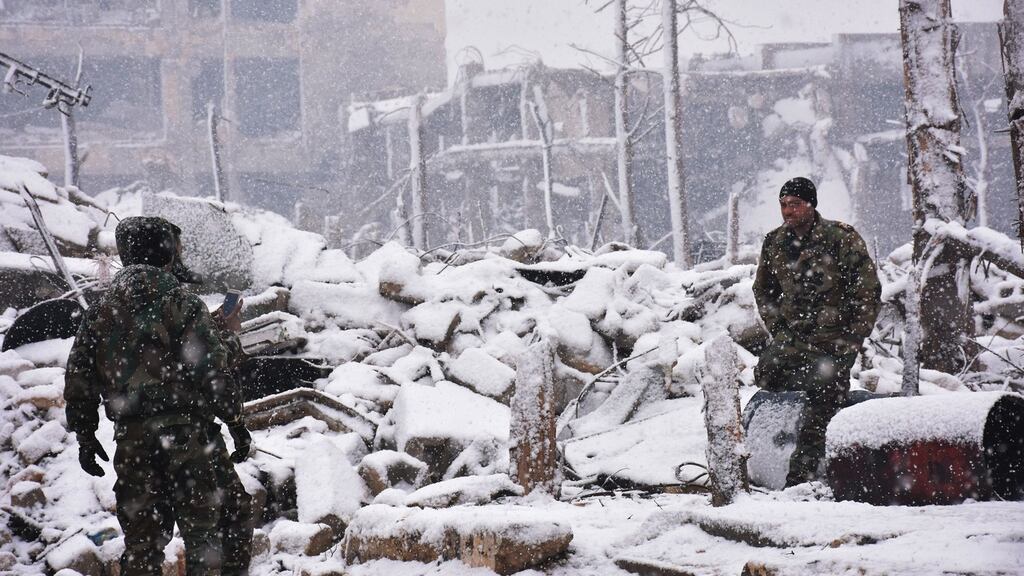 Syrian pro-government forces on patrol as snow falls in Aleppo. Photograph: George Ourfalian/AFP/Getty Images