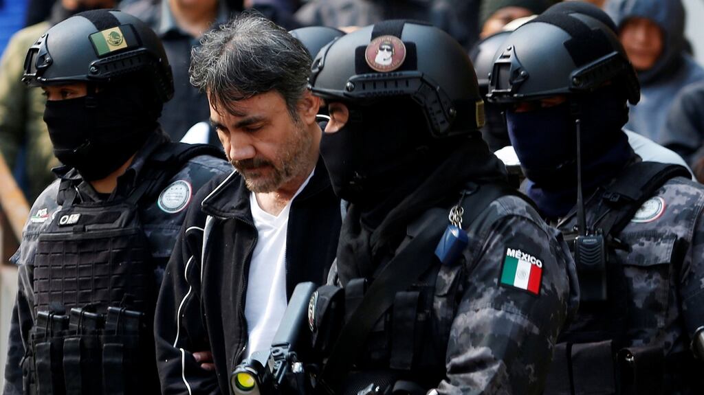 Damaso Lopez is escorted by police officers after his  arrest  in Mexico City. Photograph: Carlos Jasso/Reuters