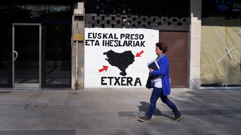 A woman walks past a mural in favour of imprisoned Eta members in the Basque town of Amorebieta, northern Spain, on Thursday. Photograph: Vincent West/Reuters