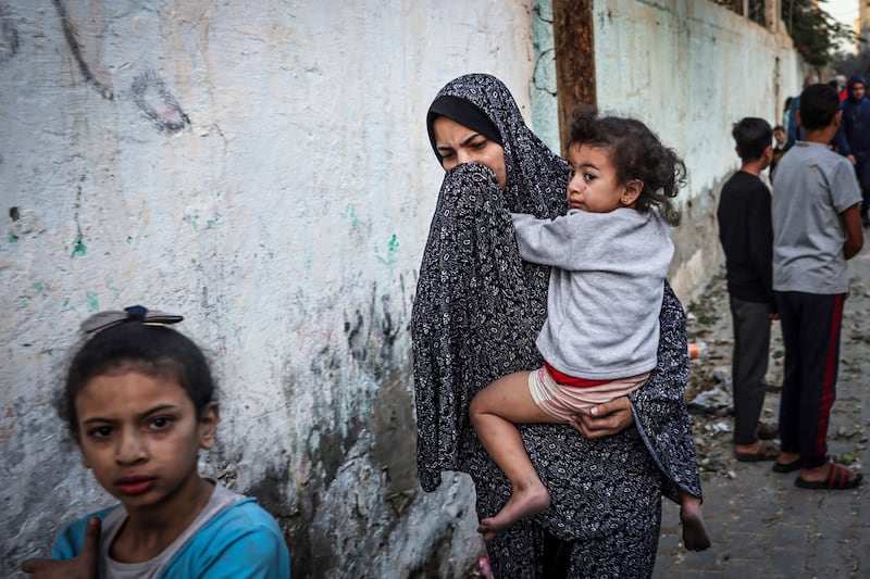 A woman holding a child flees following an Israeli strike in Rafah in the southern Gaza Strip on November 23rd. Photograph: Mohammed Abed/AFP via Getty Images