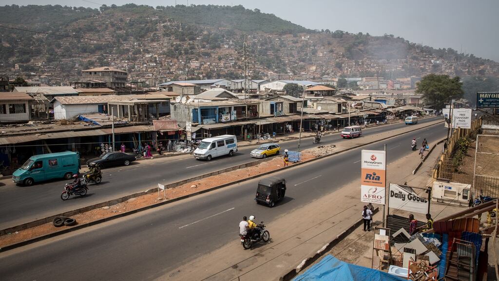An okada motorbike driver carries a passenger in eastern Freetown, Sierra Leone. Photograph: Sally Hayden