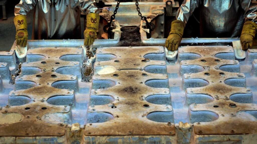 Alcoa  employees release molten aluminum into a vertical cast for cylindrical billets at ta  production plant in  South Carolina. Photographer: Stephen Morton/Bloomberg