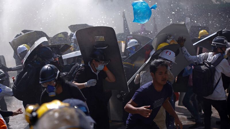 Protesters are dispersed as riot police fire tear gas during a demonstration in Yangon on Monday. Photograph: AP