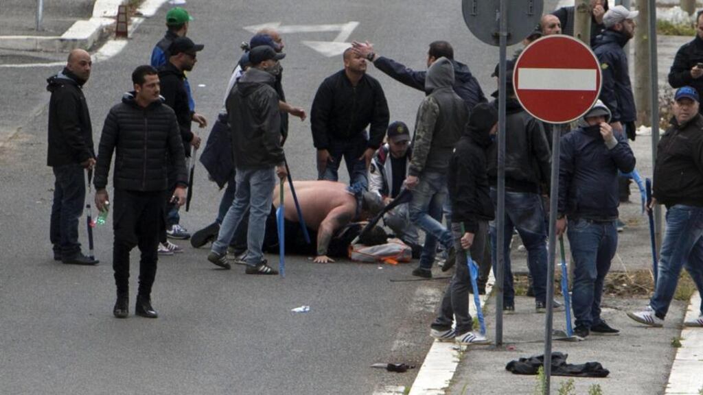A Napoli supporter is treated after being wounded by a gun shot during clashes before the Italian Cup final between Napoli and Fiorentina near the Stadio Olimpico in Rome. Photograph: Massimo Percossi/EPA