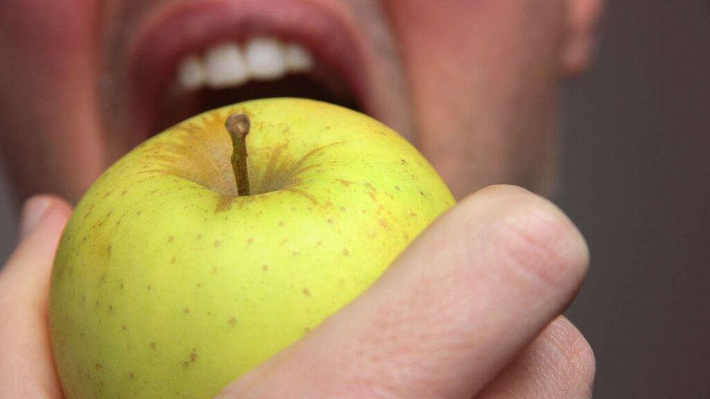 In ‘An Apple in a Library’ a man scoffs an apple and then contrives, impossibly, to un-eat it: “a waxy, green ribbon peels out from the reader’s mouth...” Photograph: Istock
