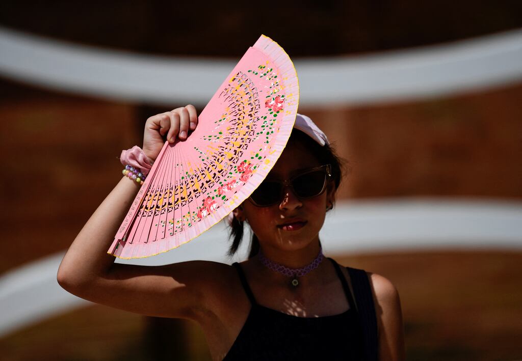 A woman protects herself from the sun with a fan during the first heatwave of the summer in Seville, Spain. Photograph: Cristina Quicler/Getty