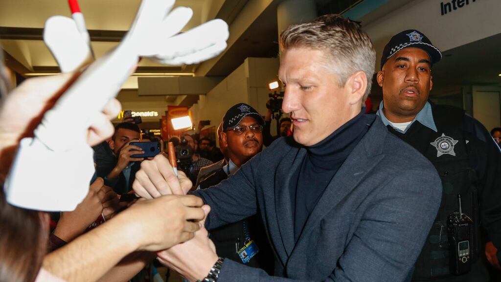 Bastian Schweinsteiger signs autographs after arriving at O’Hare International Airport in Chicago. The former German international has signed a deal with MLS club Chicago Fire. Photograph: Kamil Krzaczynski/EPA