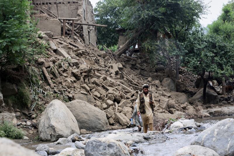 A man and boy cross a stream next to a house destroyed by an earthquake that resulted in the deaths of many people and destroyed villages in eastern Afghanistan. Photograph: Wahidullah Kakar/AP