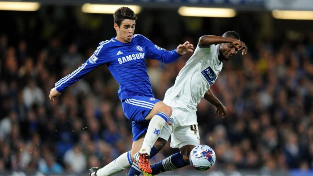 Chelsea goalscorer Oscar (left) and Bolton Wanderers’ Mohamed Medo battle for the ball during the League Cup third round match at Stamford Bridge, London.
