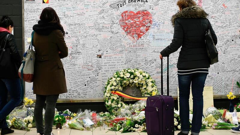 People stand in front of a remembrance wall at the Maelbeek metro station in Brussels. Photograph: Joh Thys/AFP/Getty Images