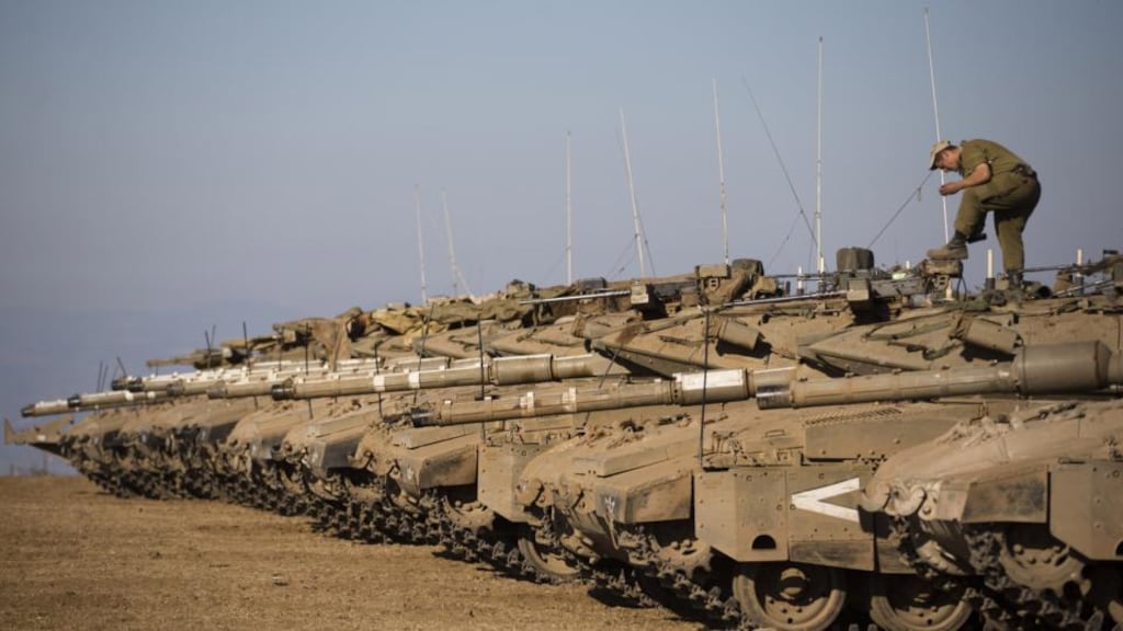 A soldier cleans his shoes on top of a tank as Israeli troops take part in a military exercise yesterday near the border of Syria, in the Israeli-annexed Golan Heights. Irish troops are to be deployed in mid-September to the United Nations Disengagement Observer Force in the area. Photograph: Uriel Sinai/Getty Images