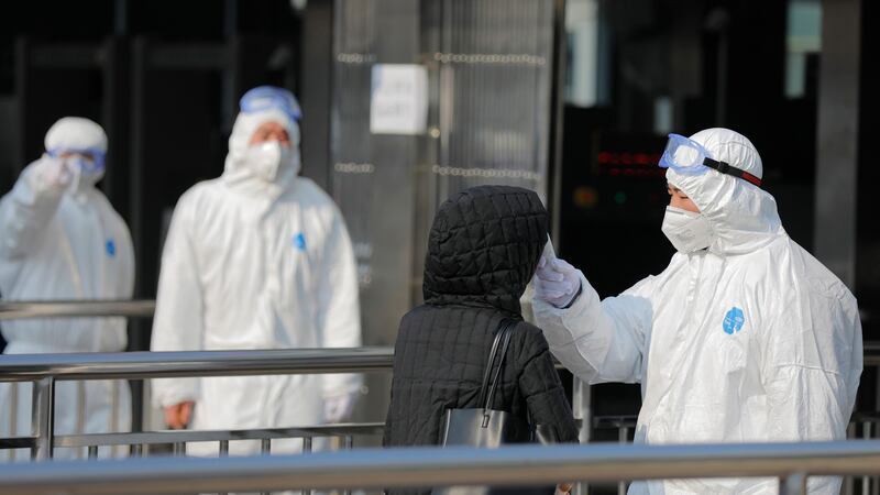 Security personnel wearing hazardous material suits measure body temperatures of passenger at the entrance of a subway station in Beijing, China, January 25th 2020. Photograph: Wu Hong/EPA
