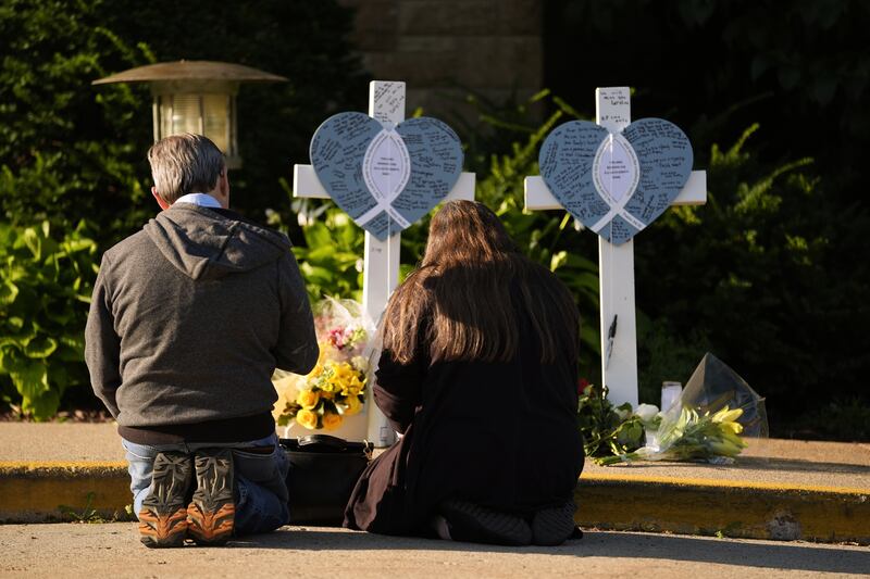 Tim and Katharine Barr kneel and pray at a memorial at Annunciation Catholic Church after Wednesday’s school shooting in Minneapolis. Photograph: Abbie Parr/AP