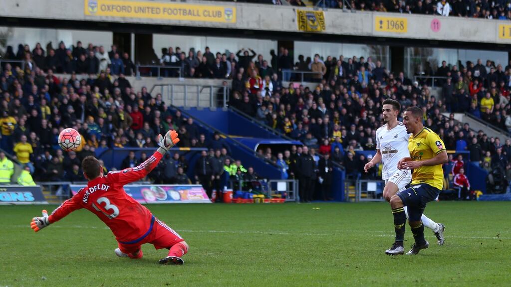 Oxford United’s Kemar Roofe scores his second goal past Swansea City goalkeeper Kristoffer Nordfeldtl during the FA Cup third-round match at the Kassam Stadium. Photograph: Michael Steele/Getty Images