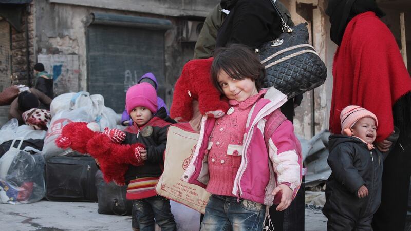 Women and children with their baggage await evacuating from the eastern part of Aleppo on Thursday. Photograph: Ghith Sy/EPA