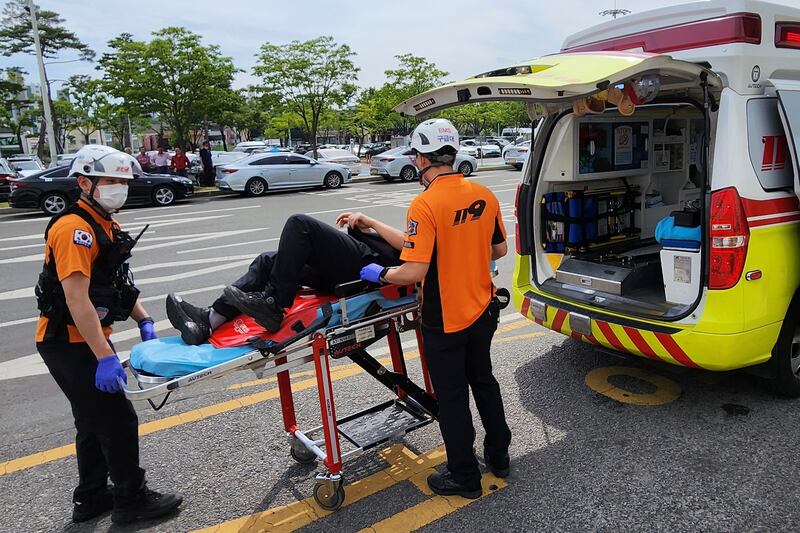 Rescue workers move a passenger on a stretcher to an ambulance at Daegu International Airport. Photograph: Daegu Fire Station/Newsis via AP