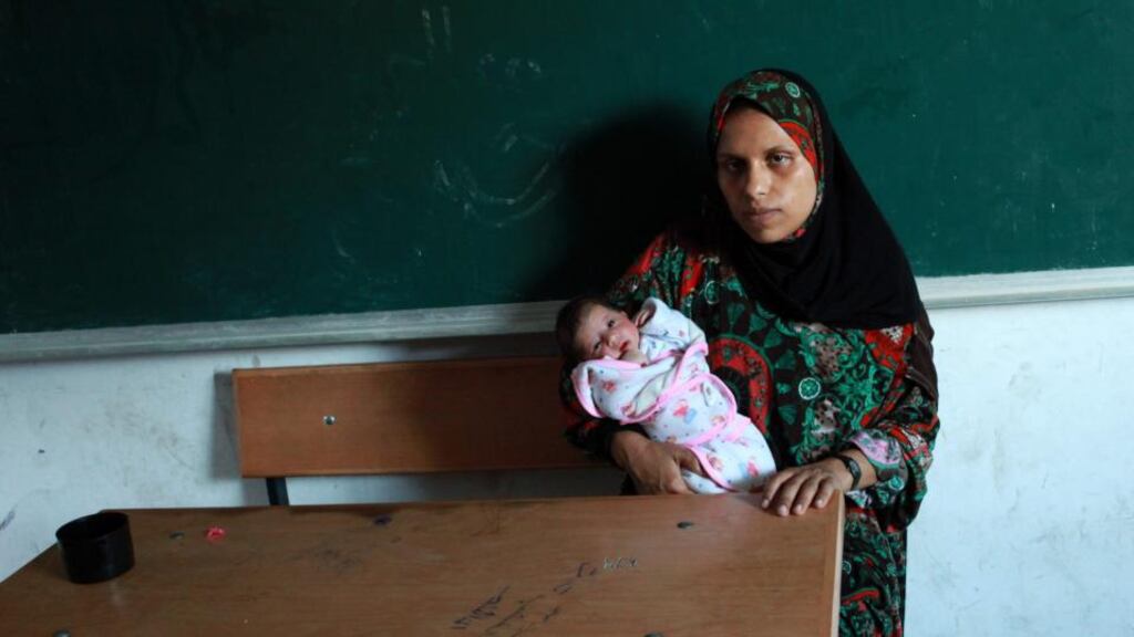 Fatma Ihjela (28)  holds her two-day-old baby whom she has named Gaza Tuqawem (translated in English means “Gaza Resists”) as she rests at a United Nations-run school after fleeing from the Al-Shejaeiya neighbourhood in Gaza City today. Photograph: Mohammed Saber/EPA