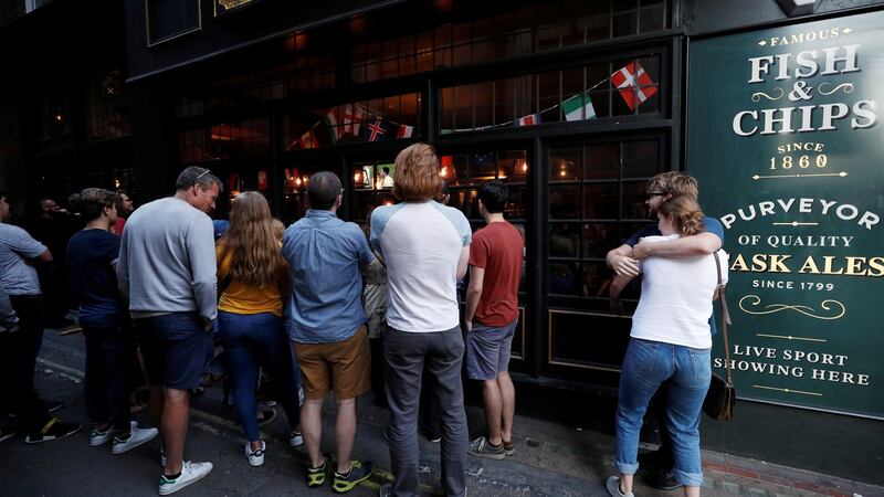 England fans watch the match outside of a pub in London. Photo: Phil Noble/Reuters