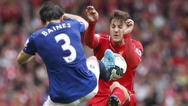 Liverpool’s Adam Lallana (right) and Everton’s Leighton Baines battle for possession at Anfield. Photograph: Andrew Yates / Reuters