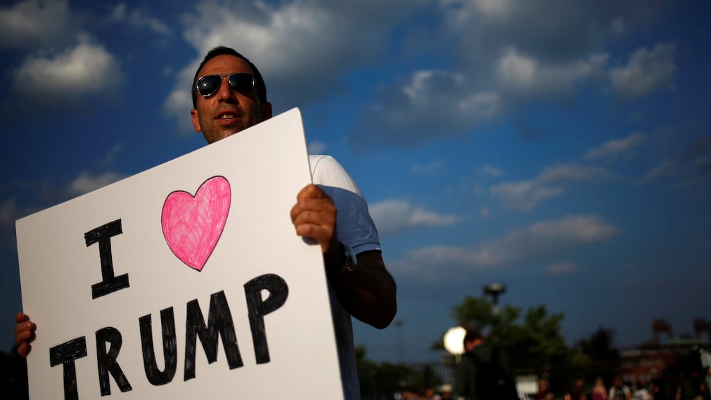 A man holds an "I Love Trump" sign along the perimeter walls of the 2016 Democratic National Convention in Philadelphia, Pennsylvania on July 27, 2016. REUTERS/Adrees Latif